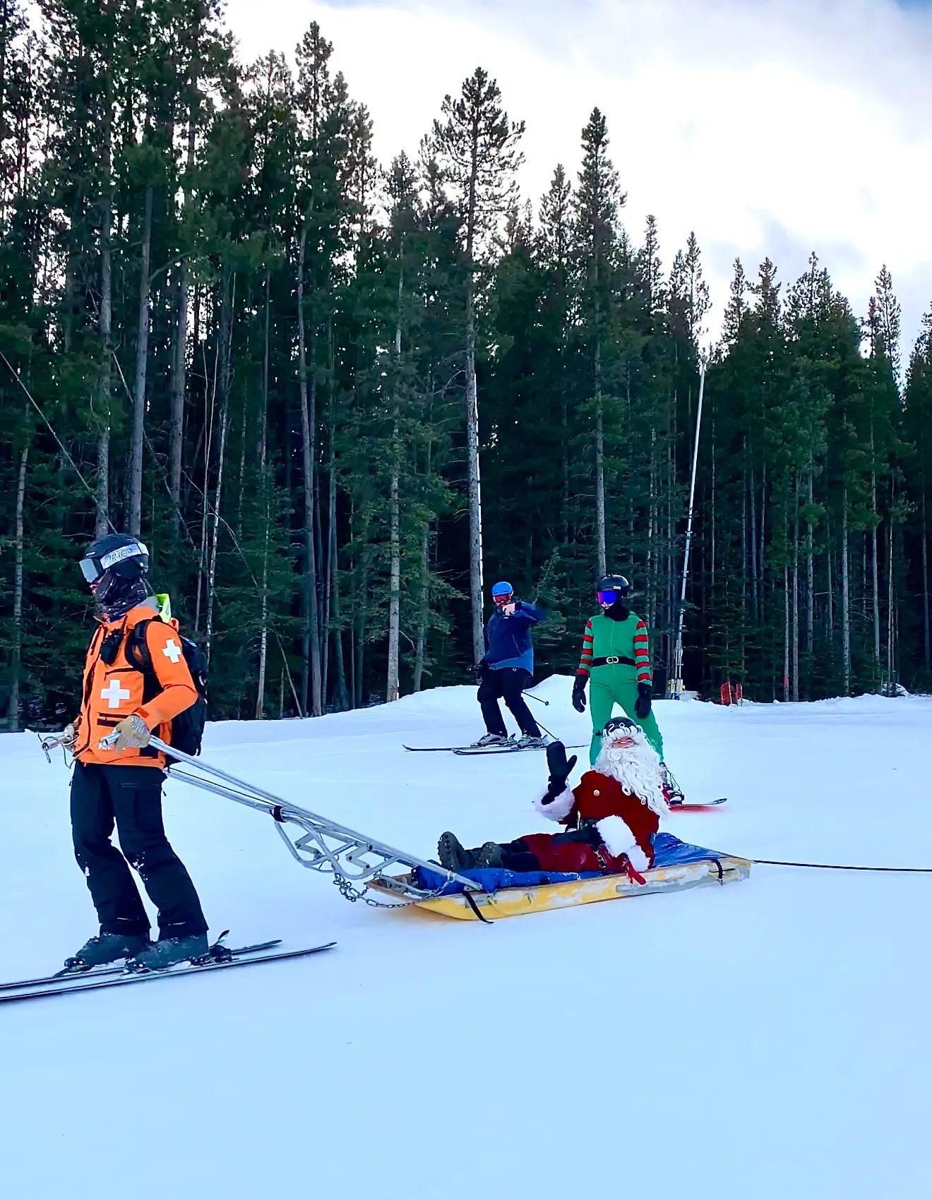 Founder Chad dressed as Santa, towed down the run on a ski-patrol rescue sled